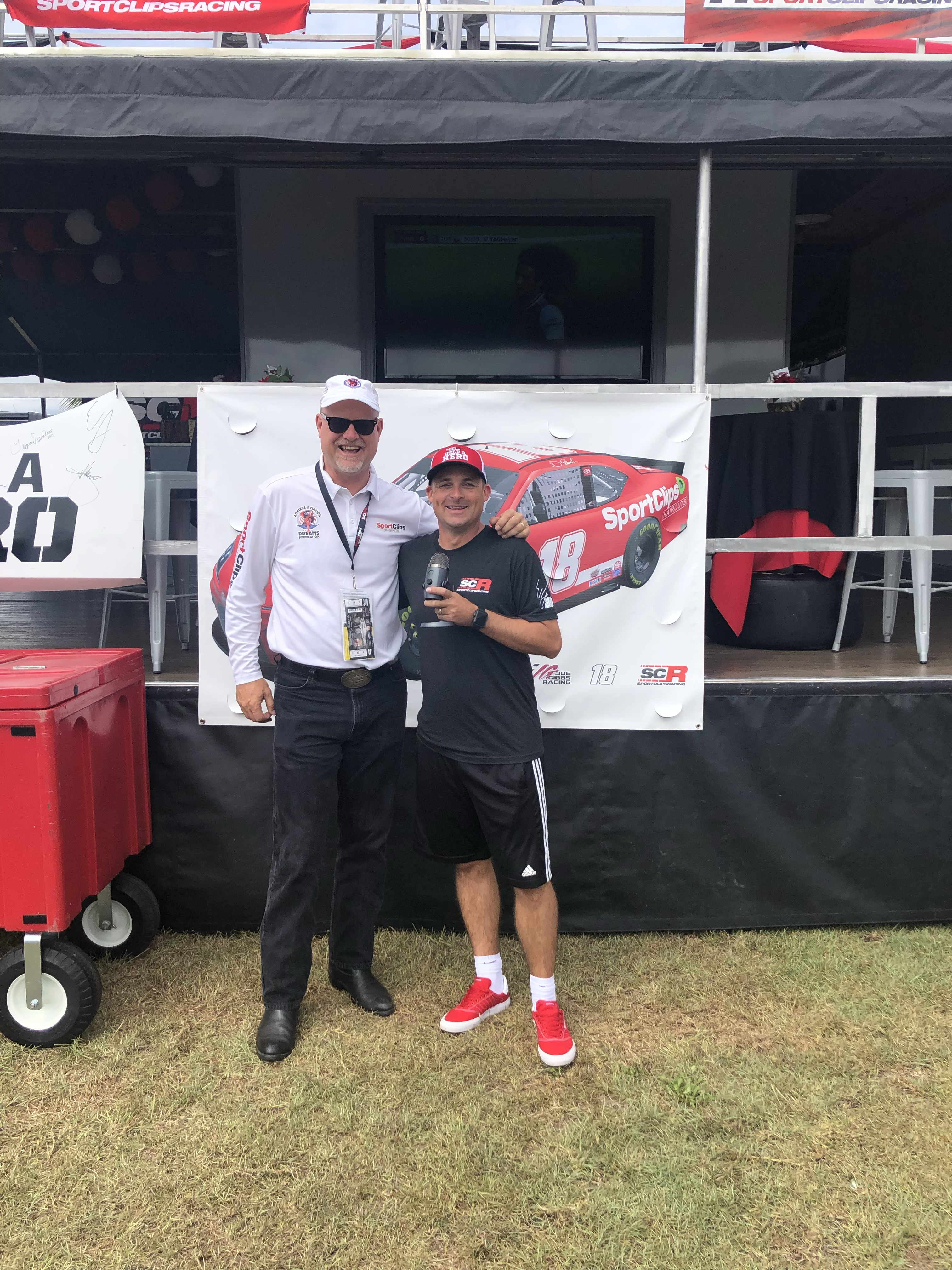 Chad Jordan and Darryl Fisher holding a microphone at Darlington Racetrack