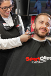 Sport Clips stylist with scissors and mask